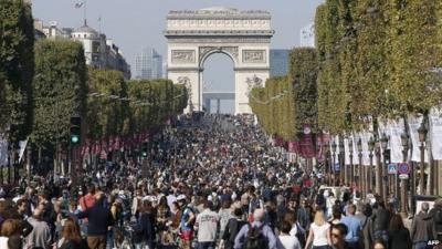 Crowds of pedestrians and cyclists on the Champs-Elysees