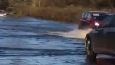 Cars driving through floods