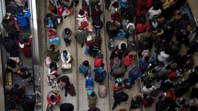 Passengers queue at the train station as they prepare to travel to their hometowns for the "Spring Festival" or Lunar New Year on January 23, 2017 at Beijing south Railway Station