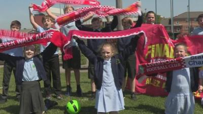 Image shows a still from video of Liverpool fans with their scarves