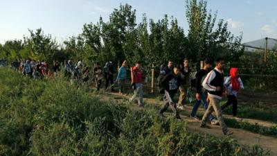 A group of migrants rest on the Serbian side of the border near Sid, 16 September 2015.