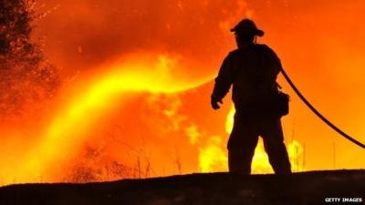 Firefighter douses flames near Clearlake, California on August 2, 2015