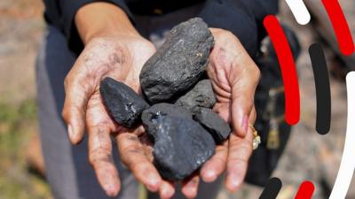 Lumps of coal held in hands