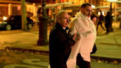 A victim is escorted outside the Bataclan concert hall