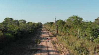 Children running along the road in the Chaco forest