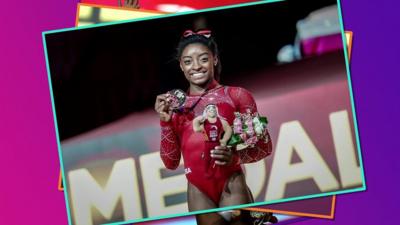 Simone Biles holding medals