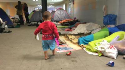Young child and migrants sleeping in Keleti station subway