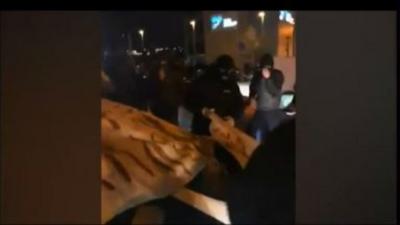 Demonstrators kick police car