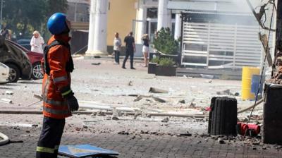 - Ukrainian emergency services worker looks at debris