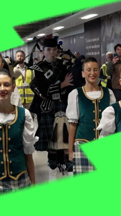 Man playing pipes with Highland dancers