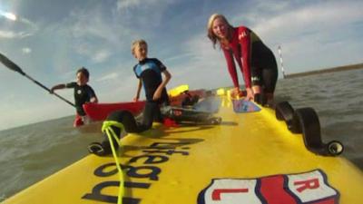 The boys with the lifeguard that rescued them.