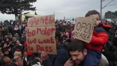 Children holding 'open borders' signs