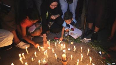 People light candles for the victims of the Tunisia killings