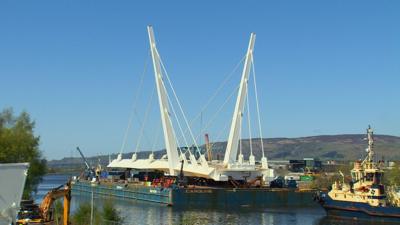 One section of the bridge is towed along the River Clyde.