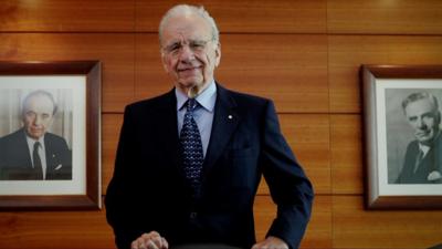 Rupert Murdoch photographed next to a portrait of his father, Keith Murdoch.