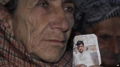 Makhni Begum holds a photograph of her son Shafqat Hussain