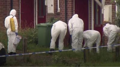 Forensic team in white overalls