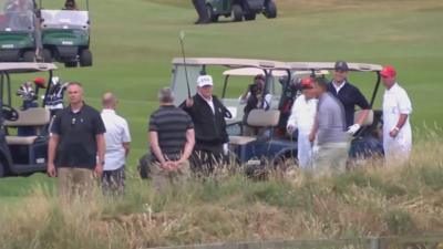 Trump waves to protestors