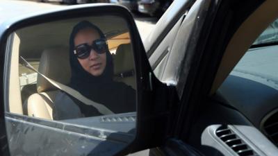 Saudi activist Manal al-Sharif makes a victory sign as she drives a car in Dubai in October 2013