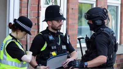 Police talking with an armed police officer