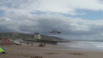 A rescue helicopter landing on Tywyn beach