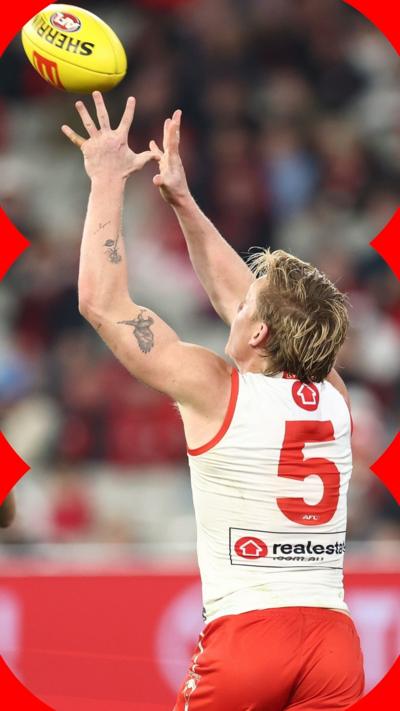 Australian Football League player with a number five red and white jersey catching a ball