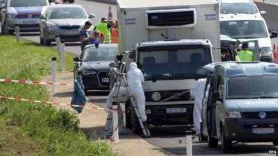 Forensic experts investigate a truck in which migrants were found dead as it stands on freeway autobahn A4 between Parndorf and Neusiedl, Austria