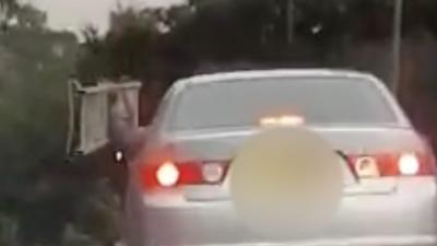 Passengers holding ladder out of car window