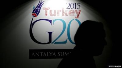 Man walking past G20 sign