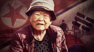 Woman in front of picture of North and South Korean flags