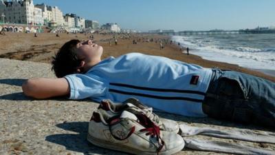 Boy sunbathing on beach