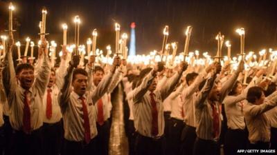 Volunteers take part in a torch-lighting performance at Kim Il-Sung square in Pyongyang on October 10