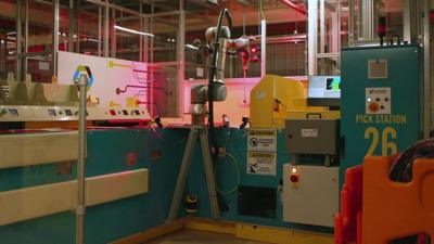 A robot putting groceries into customers' bags in a Ocado warehouse