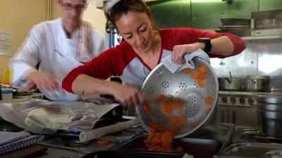 A woman empties food into a tray