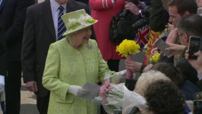 Queen Elizabeth II accepting a bouquet of daffodils