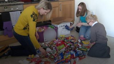 Danielle Shipman, Susan Lambe and a young girl sort materials for recycling