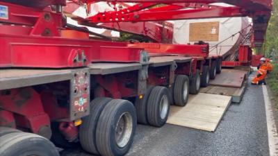 An abnormal load moves over a temporary bridge.