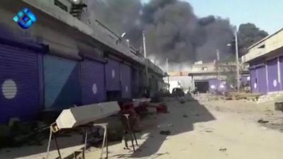 Smoke rises from a building in the Syrian border town of Ras al-Ain