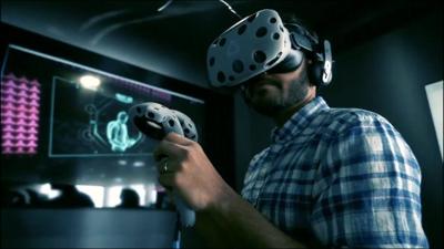 A man using a virtual reality headset and controls