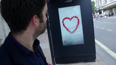 A man looking at poster which can change depending on how people respond to it