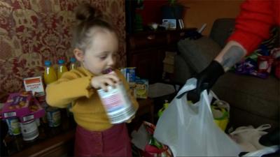 Ava, aged 2, helping to pack food bags