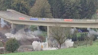 Smoke following explosions around pillars of a bridge