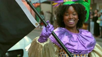 A young black woman dancing in a parade