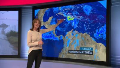 Louise Lear stands in front of BBC Weather map which shows Hurricane Matthew