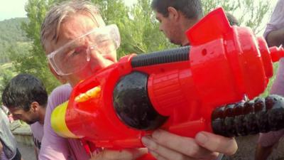 Reporter Rafael Estefania holding a water pistol