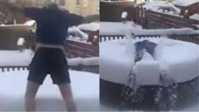 Man diving on snow covered trampoline