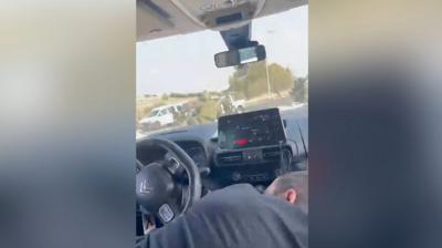 Man hides inside the car as soldiers run on road in Israel