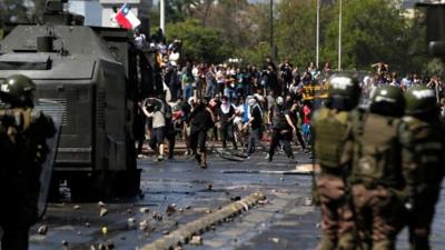 Demonstrators face off against the police during a protest in Santiago