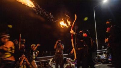 Protester shooting a flaming arrow