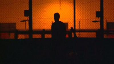 A man's silhouette at Calais fence